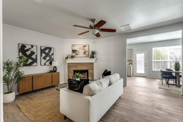 33 Verde Ranch Loop, Leander, TX 78641 - living room featuring light wood-style floors, a fireplace, a ceiling fan, and baseboards