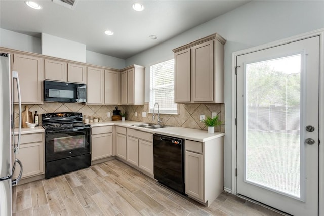 33 Verde Ranch Loop, Leander, TX 78641 - kitchen featuring black appliances, a sink, light countertops, tasteful backsplash, and light wood-style floors