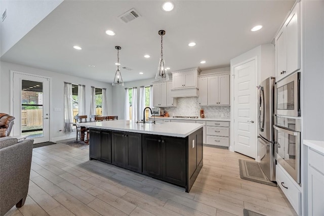 104 Trans Pecos Ct, Georgetown, TX 78628 - kitchen with stainless steel appliances, light countertops, light wood finished floors, white cabinetry, and recessed lighting