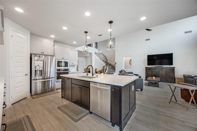 104 Trans Pecos Ct, Georgetown, TX 78628 - kitchen featuring appliances with stainless steel finishes, light wood-style flooring, light countertops, open floor plan, and recessed lighting