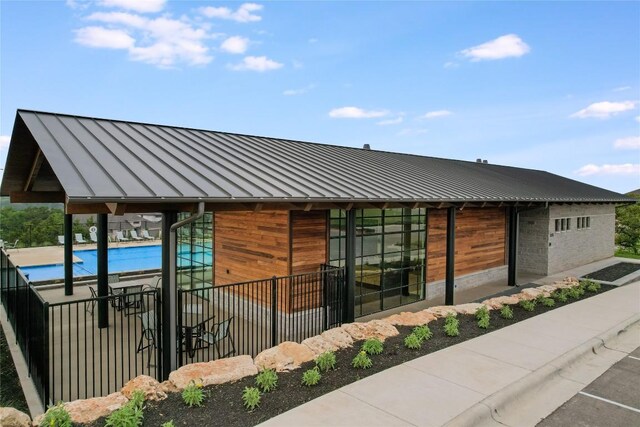 104 Trans Pecos Ct, Georgetown, TX 78628 - view of side of home featuring a standing seam roof, a metal roof, and a community pool