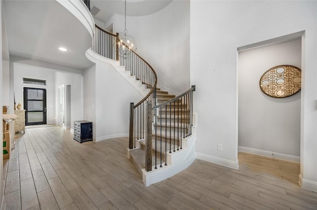 104 Trans Pecos Ct, Georgetown, TX 78628 - stairway featuring wood finished floors, a towering ceiling, a chandelier, and recessed lighting