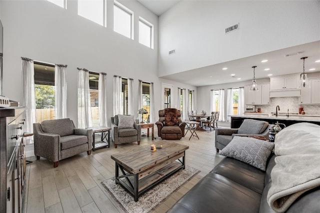 104 Trans Pecos Ct, Georgetown, TX 78628 - living area with plenty of natural light, a towering ceiling, light wood-style flooring, and recessed lighting