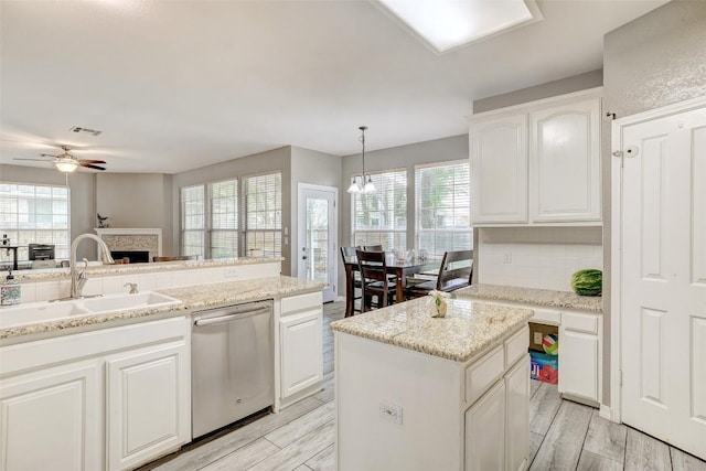 30003 Oakland Hills Dr, Georgetown, TX 78628 - kitchen featuring dishwasher, a ceiling fan, a fireplace, white cabinets, and light wood-type flooring