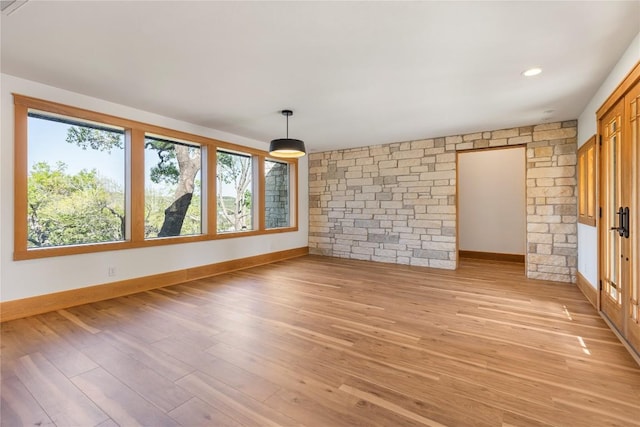 spare room featuring baseboards and light wood-type flooring