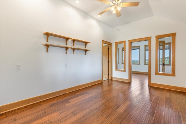 empty room with dark wood-type flooring, baseboards, a ceiling fan, and lofted ceiling