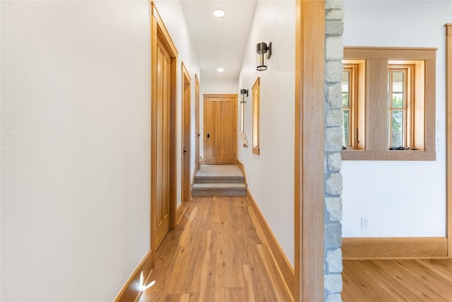 corridor featuring light wood-type flooring, baseboards, and recessed lighting