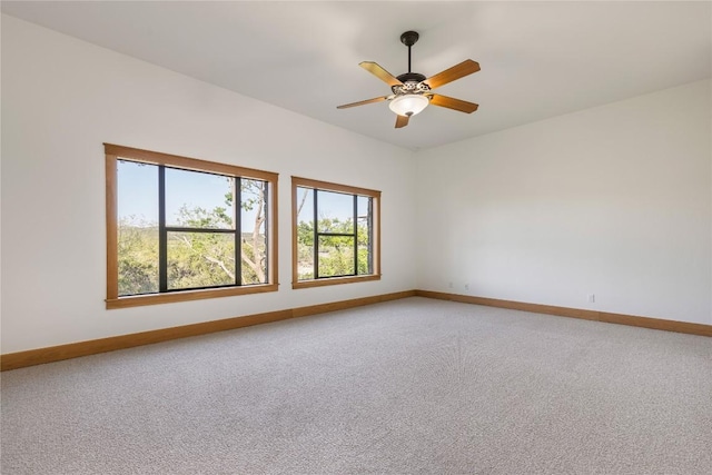 spare room with ceiling fan, light colored carpet, and baseboards