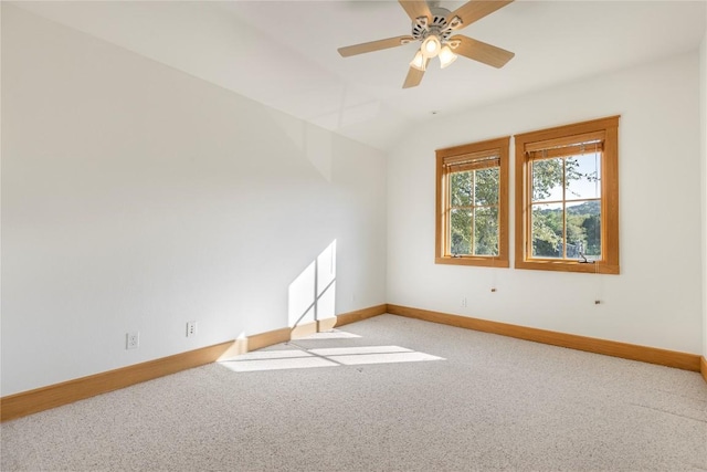 spare room featuring light carpet, baseboards, a ceiling fan, and lofted ceiling