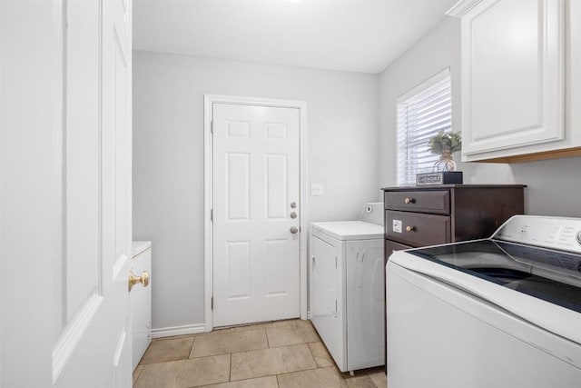 washroom with separate washer and dryer, light tile patterned floors, and cabinet space