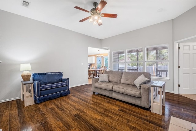 living area with wood finished floors, visible vents, baseboards, and ceiling fan with notable chandelier