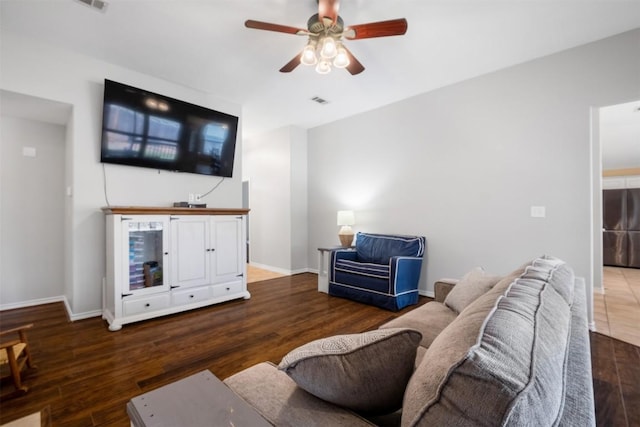living room with ceiling fan, baseboards, and wood finished floors