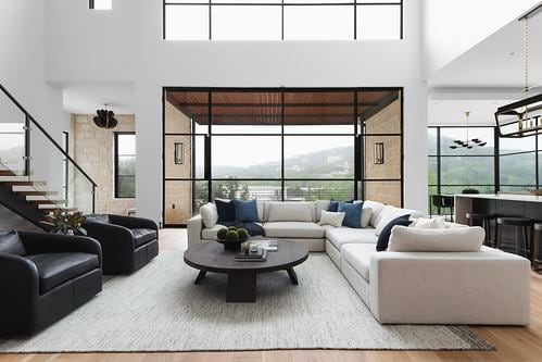 2701 Toro Canyon Rd Unit B, Austin, TX 78746 - living room featuring wood finished floors, a towering ceiling, healthy amount of natural light, and stairs