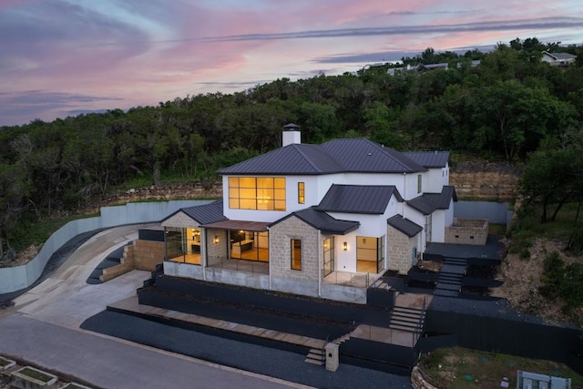2701 Toro Canyon Rd Unit B, Austin, TX 78746 - back of property with stone siding, a chimney, metal roof, and a standing seam roof