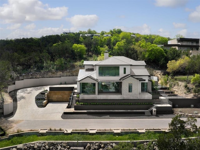 2701 Toro Canyon Rd Unit B, Austin, TX 78746 - back of house featuring concrete driveway, metal roof, and a chimney