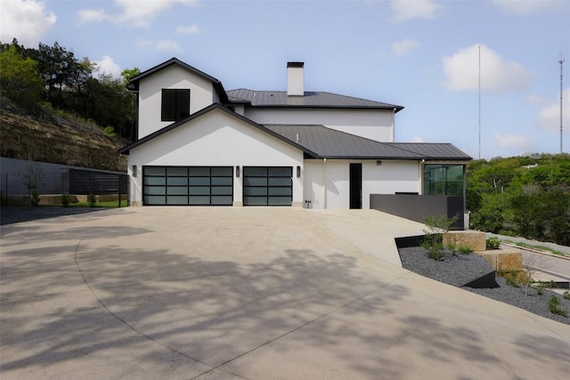 2701 Toro Canyon Rd Unit B, Austin, TX 78746 - view of front of home featuring a standing seam roof, stucco siding, concrete driveway, and a chimney