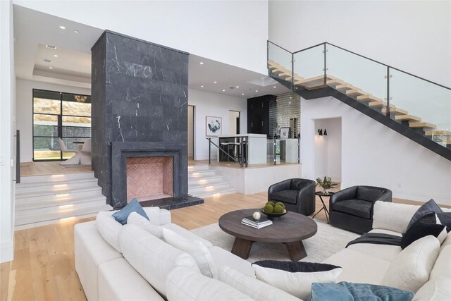 2701 Toro Canyon Rd Unit B, Austin, TX 78746 - living room featuring stairway, wood finished floors, a high ceiling, a fireplace, and recessed lighting