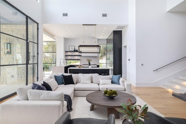 2701 Toro Canyon Rd Unit B, Austin, TX 78746 - living room with wood finished floors, a towering ceiling, and stairs