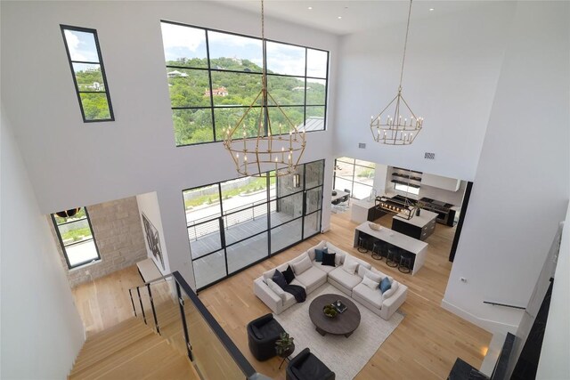 2701 Toro Canyon Rd Unit B, Austin, TX 78746 - living room with a chandelier, a high ceiling, wood finished floors, and plenty of natural light