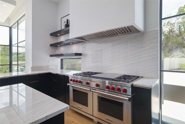 2701 Toro Canyon Rd Unit B, Austin, TX 78746 - kitchen featuring double oven range, dark cabinets, custom range hood, open shelves, and recessed lighting