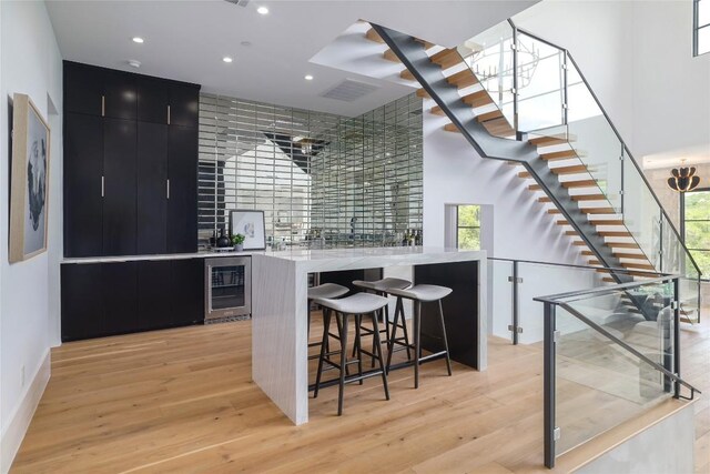 2701 Toro Canyon Rd Unit B, Austin, TX 78746 - bar area featuring beverage cooler, light wood-style floors, recessed lighting, and stairs