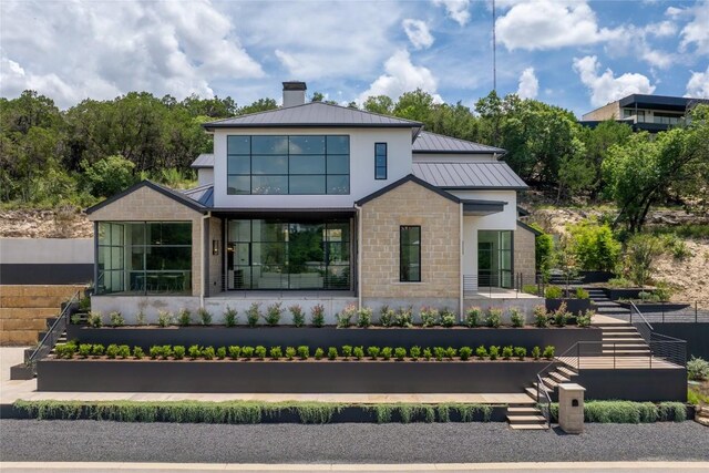 2701 Toro Canyon Rd Unit B, Austin, TX 78746 - rear view of house with a standing seam roof, a chimney, a metal roof, and stone siding
