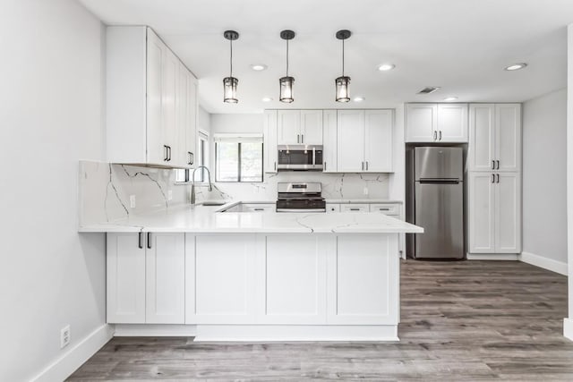 2009 Scofield Ln, Austin, TX 78727 - kitchen with appliances with stainless steel finishes, a peninsula, recessed lighting, and white cabinetry