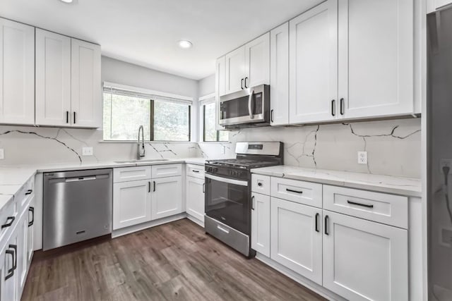 2009 Scofield Ln, Austin, TX 78727 - kitchen with appliances with stainless steel finishes, a sink, recessed lighting, backsplash, and white cabinets