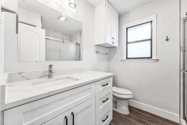 2009 Scofield Ln, Austin, TX 78727 - bathroom with vanity, a shower stall, wood finished floors, toilet, and baseboards