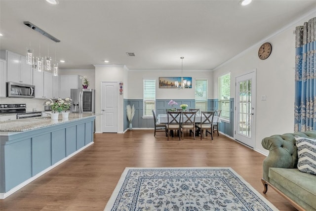 dining space with recessed lighting, visible vents, a chandelier, crown molding, and wood finished floors