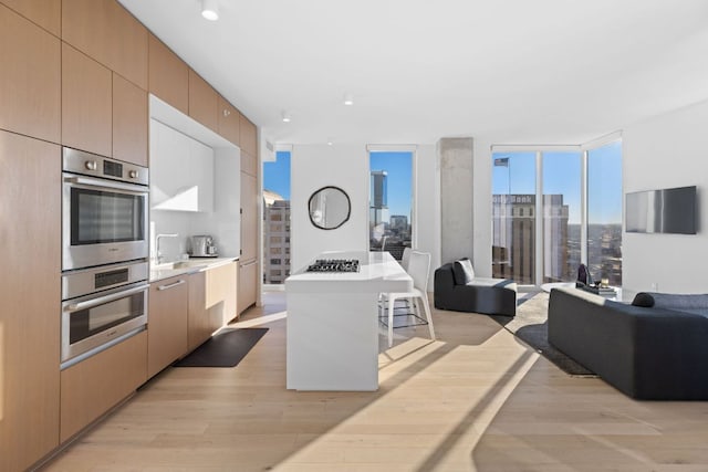 313 W 17th St Unit 1605, Austin, TX 78701 - kitchen featuring open floor plan, stainless steel appliances, light wood finished floors, a kitchen breakfast bar, and floor to ceiling windows