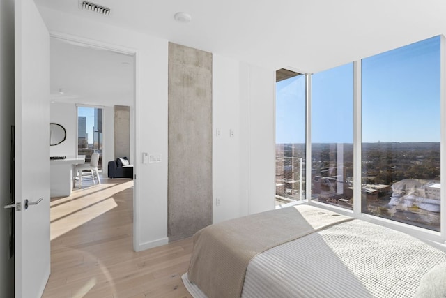 313 W 17th St Unit 1605, Austin, TX 78701 - bedroom featuring light wood finished floors and floor to ceiling windows