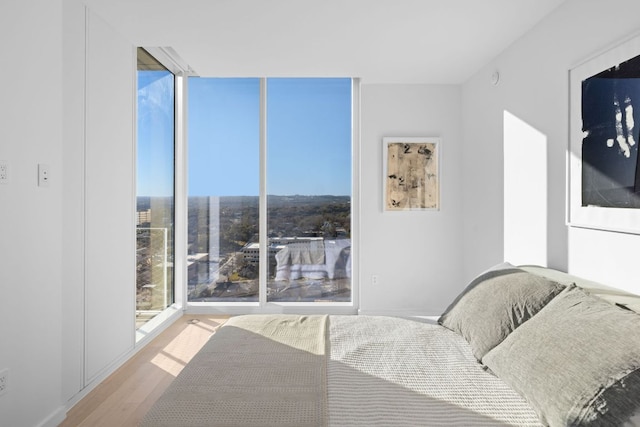 313 W 17th St Unit 1605, Austin, TX 78701 - bedroom with wood finished floors, multiple windows, and floor to ceiling windows