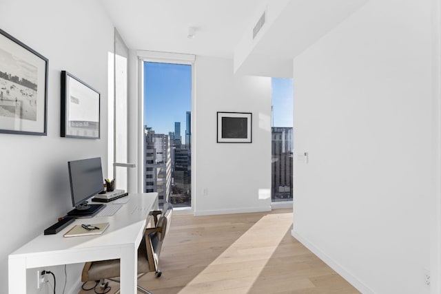 313 W 17th St Unit 1605, Austin, TX 78701 - home office with light wood-style floors, baseboards, and expansive windows