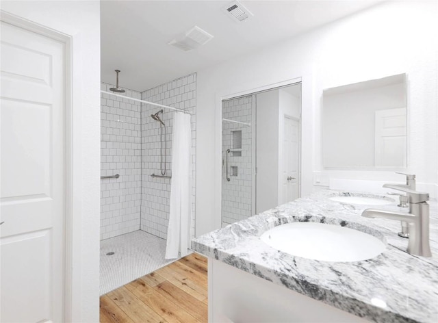 12300 Cassady Dr, Austin, TX 78727 - bathroom with a shower stall, double vanity, and wood finished floors