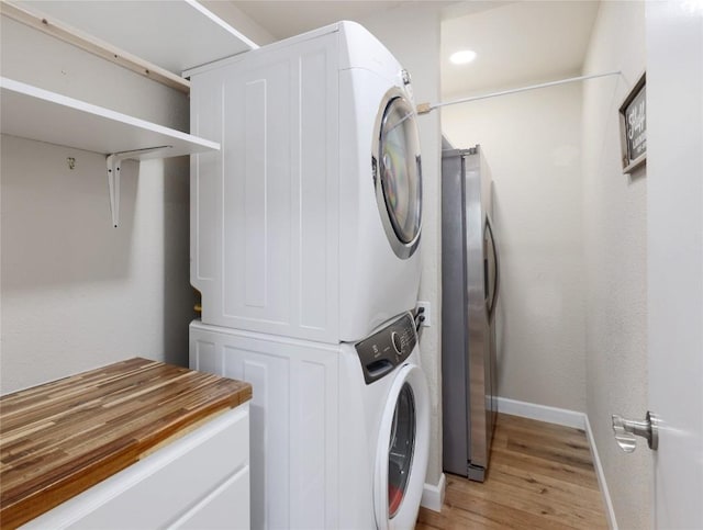 12300 Cassady Dr, Austin, TX 78727 - laundry room with stacked washer / dryer and light wood finished floors