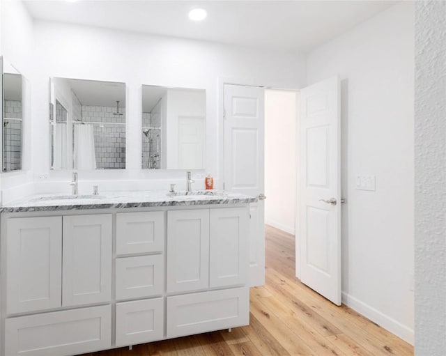 12300 Cassady Dr, Austin, TX 78727 - full bath with tiled shower, double vanity, wood finished floors, and recessed lighting