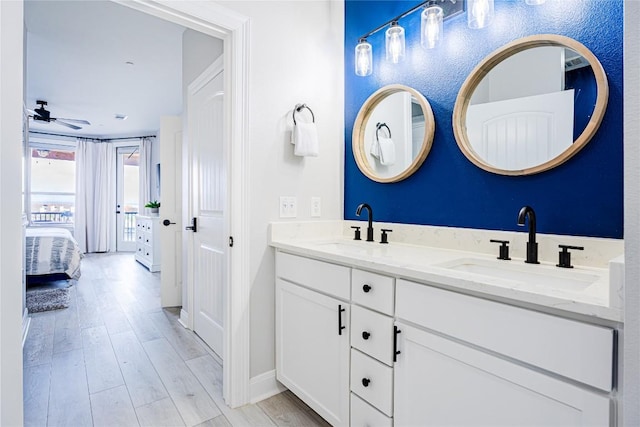 96 Island Dr Unit 44, Horseshoe Bay, TX 78657 - full bathroom with double vanity, wood finished floors, connected bathroom, and ceiling fan