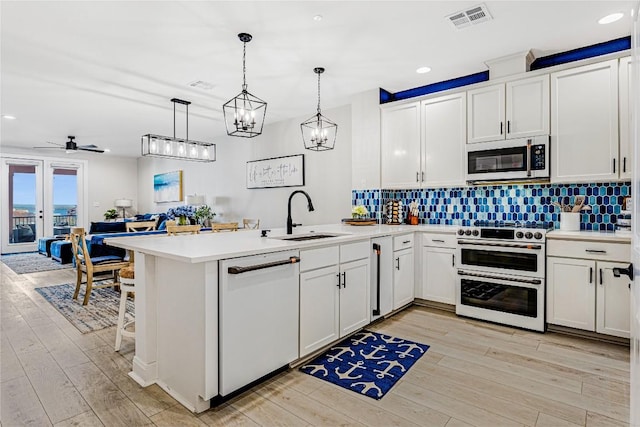 96 Island Dr Unit 44, Horseshoe Bay, TX 78657 - kitchen featuring white appliances, a peninsula, light countertops, light wood-type flooring, and recessed lighting
