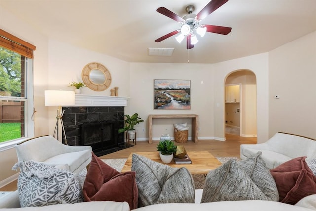 3615 Turkey Path Bnd, Cedar Park, TX 78613 - living area featuring arched walkways, a ceiling fan, wood finished floors, and a tile fireplace