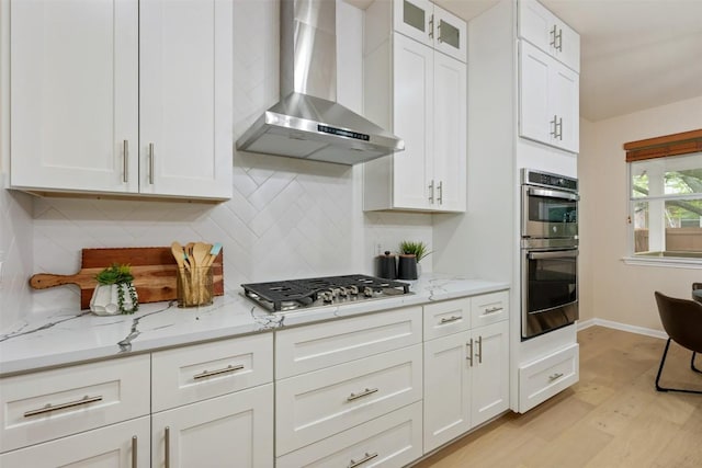 3615 Turkey Path Bnd, Cedar Park, TX 78613 - kitchen with wall chimney range hood, stainless steel appliances, white cabinetry, and light wood-type flooring