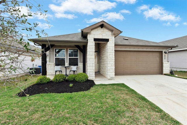 view of front of home with a garage, driveway, a front lawn, stone siding, and a shingled roof