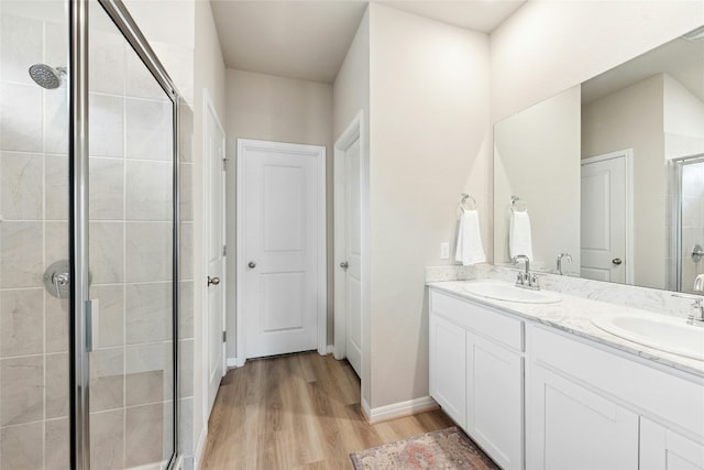 806 Vineyard Falls Rd, Austin, TX 78748 - full bathroom with a shower stall, double vanity, wood finished floors, and baseboards