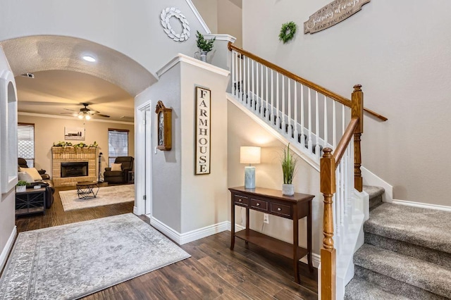 706 Belmont Dr, Georgetown, TX 78626 - staircase with baseboards, arched walkways, ceiling fan, a fireplace, and wood finished floors