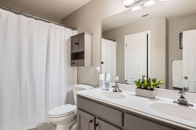 706 Belmont Dr, Georgetown, TX 78626 - full bathroom featuring toilet, a sink, double vanity, and visible vents