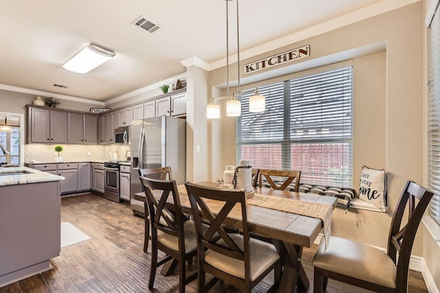 706 Belmont Dr, Georgetown, TX 78626 - dining space with visible vents, ornamental molding, and dark wood-type flooring
