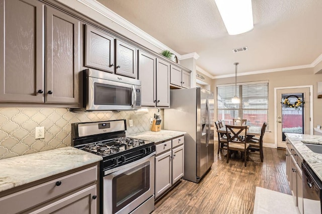 706 Belmont Dr, Georgetown, TX 78626 - kitchen featuring tasteful backsplash, ornamental molding, stainless steel appliances, dark wood-type flooring, and visible vents