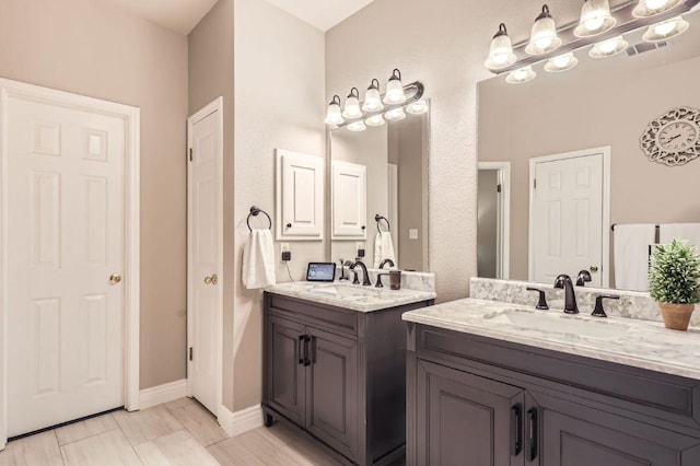 706 Belmont Dr, Georgetown, TX 78626 - full bathroom with a sink, two vanities, and baseboards