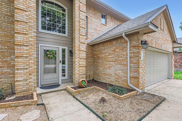 706 Belmont Dr, Georgetown, TX 78626 - view of exterior entry featuring driveway, a garage, brick siding, and roof with shingles