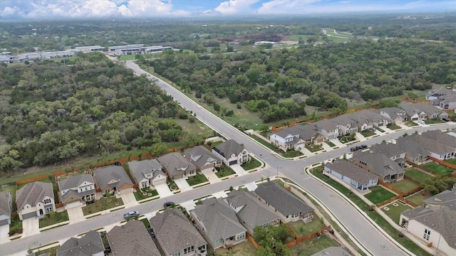 aerial view of property's location featuring nearby suburban area and a heavily wooded area